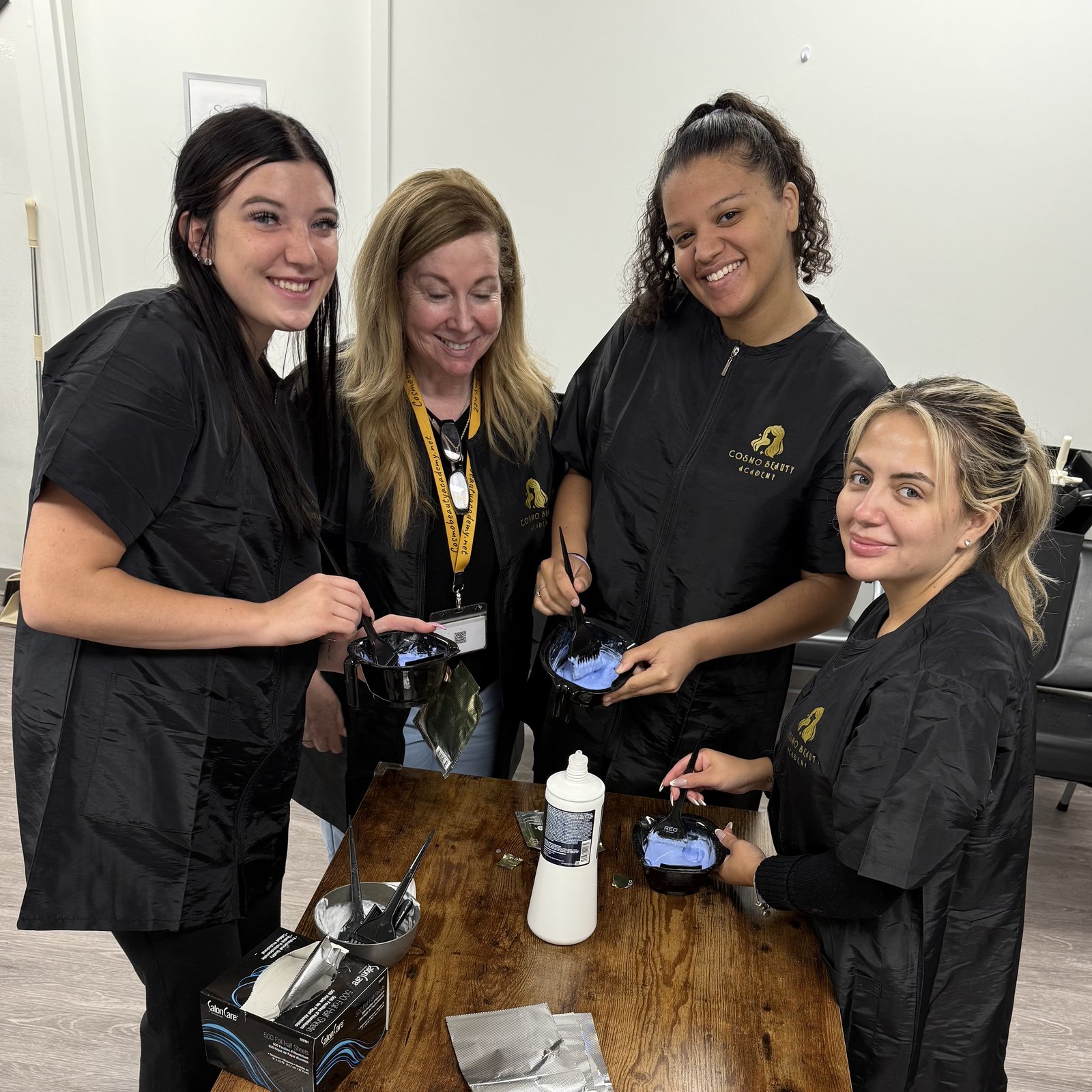 Cosmo Beauty Academy cosmetology students mixing hair color together in the classroom in Saddle Brook, New Jersey