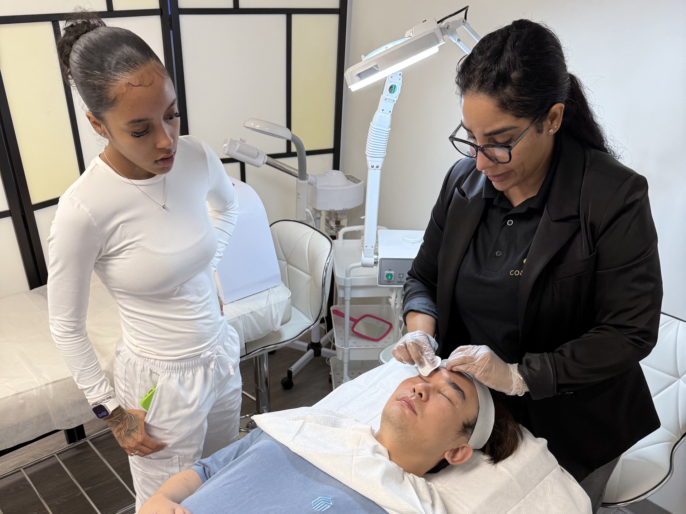 Esthetics student performing a facial treatment under instructor supervision at Cosmo Beauty Academy in Saddle Brook, New Jersey